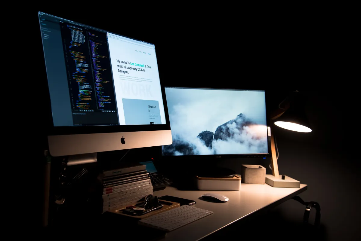 Pracoviště vývojáře se dvěma monitory a kódem