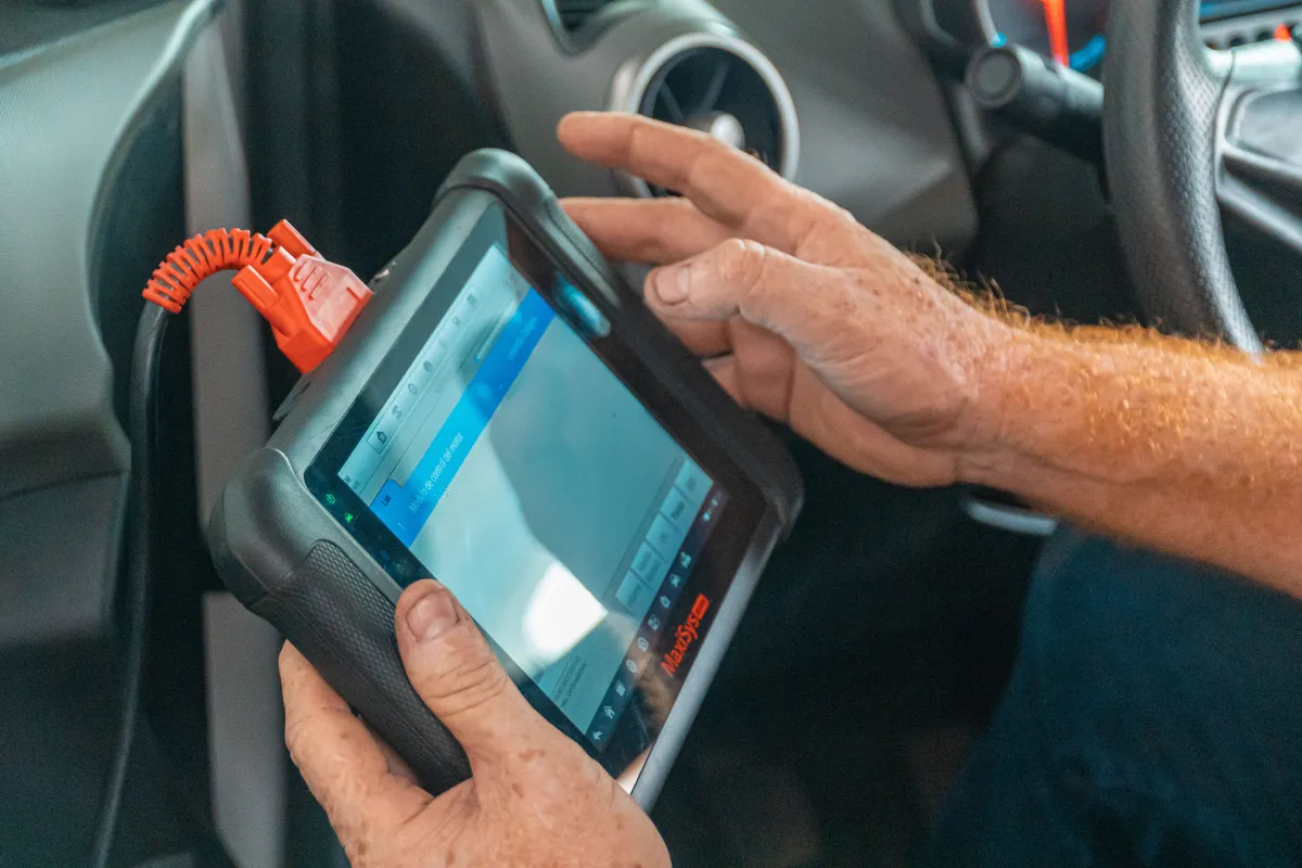 Mechanik používá diagnostický tablet u motoru vozu